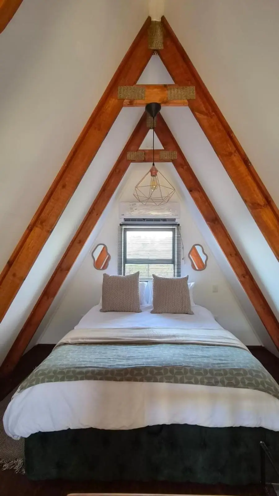 The loft bedroom: a double bed under the timber rafters