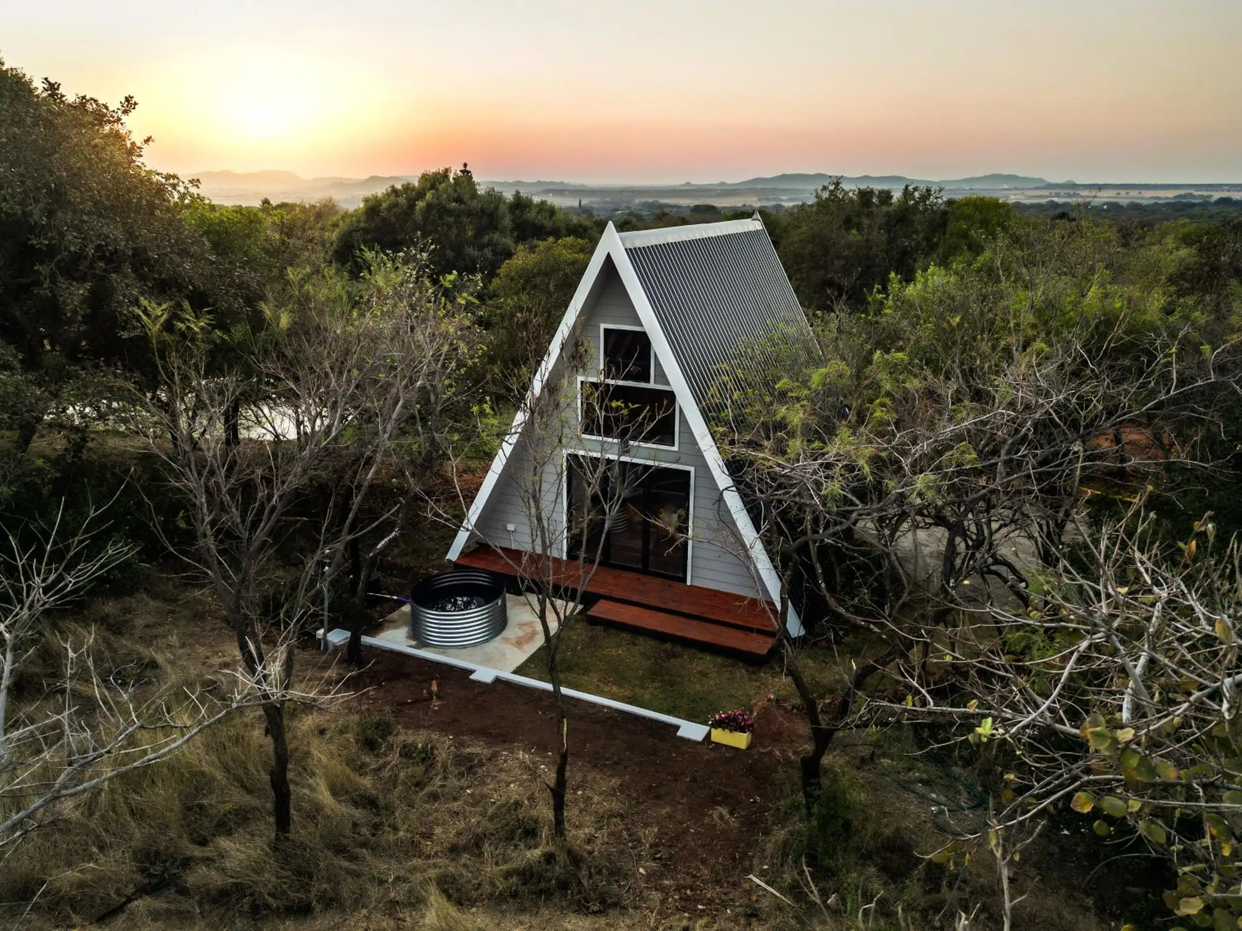 A cabin from the air at sunset, its deck and tank pool in front