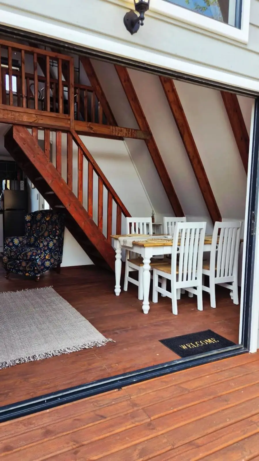 The glass doors slid open from the deck, the dining table and the stairs inside
